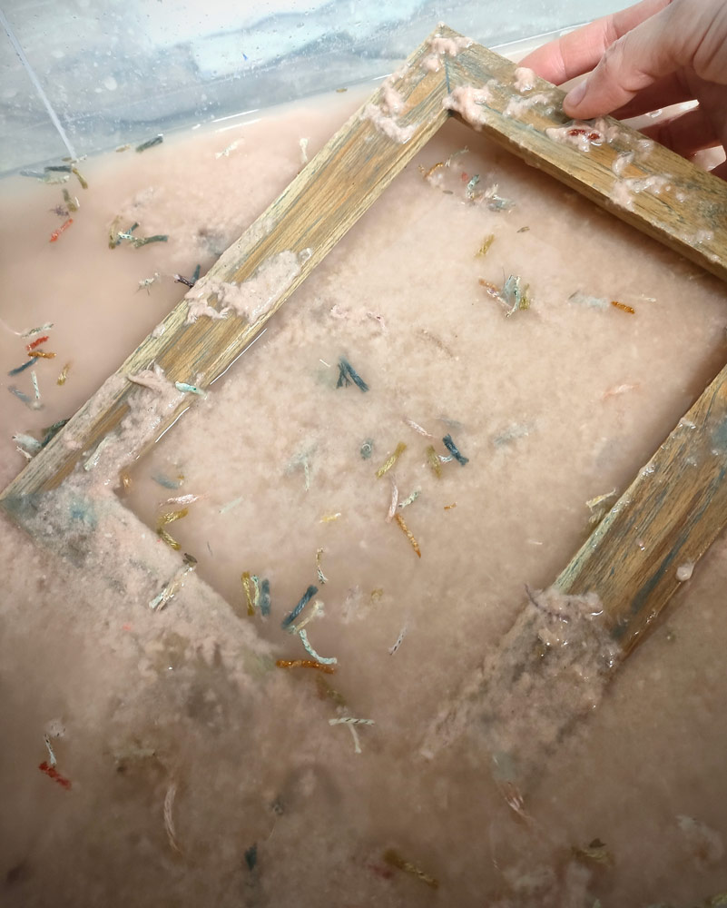 Telaio immerso nell’impasto durante la lavorazione della carta