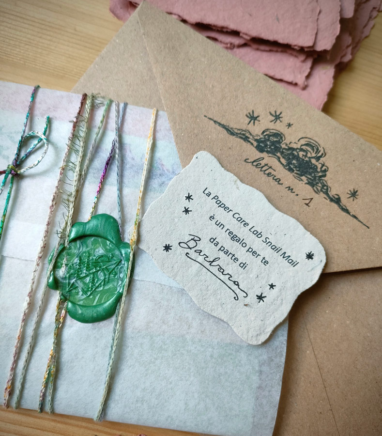 Una Snail Mail con sigillo in ceralacca e biglietto regalo in carta fatta a mano con il nome di chi regala